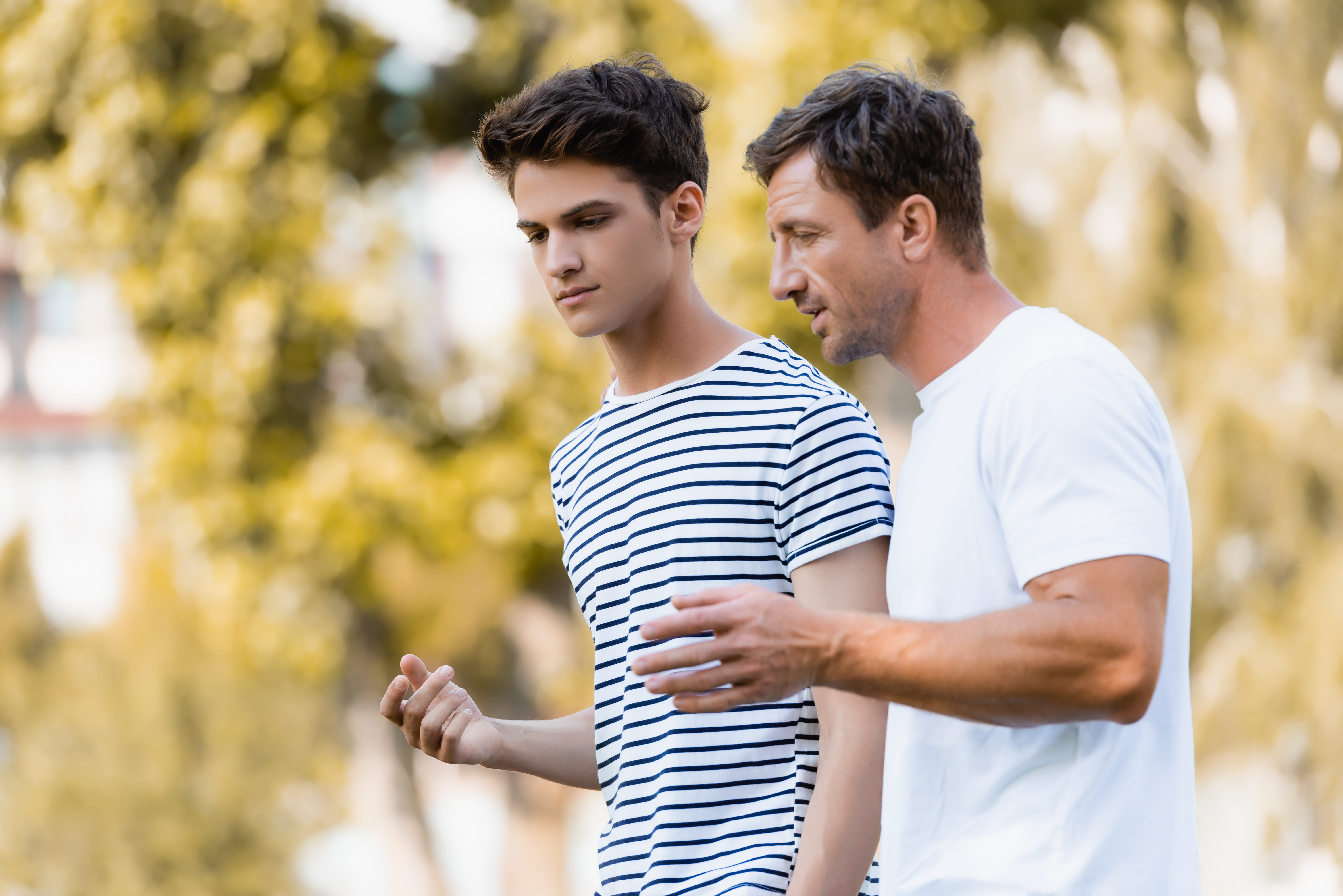 A father and son talk while walking outdoors